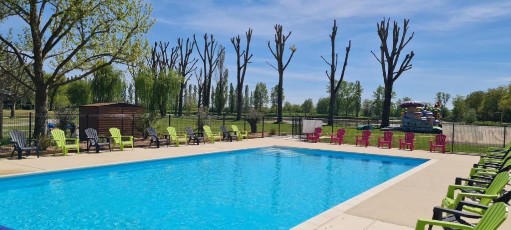a swimming pool with chairs and a fountain at L'Oasis des Dombes in Ambérieux-en-Dombes