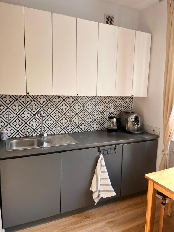 a kitchen with white cabinets and a sink at Apartament Gdynia z duszą in Gdynia