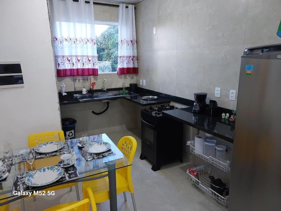 a kitchen with a table and yellow chairs and a counter at Studio com varanda - Melhor localização do Arruda in Recife