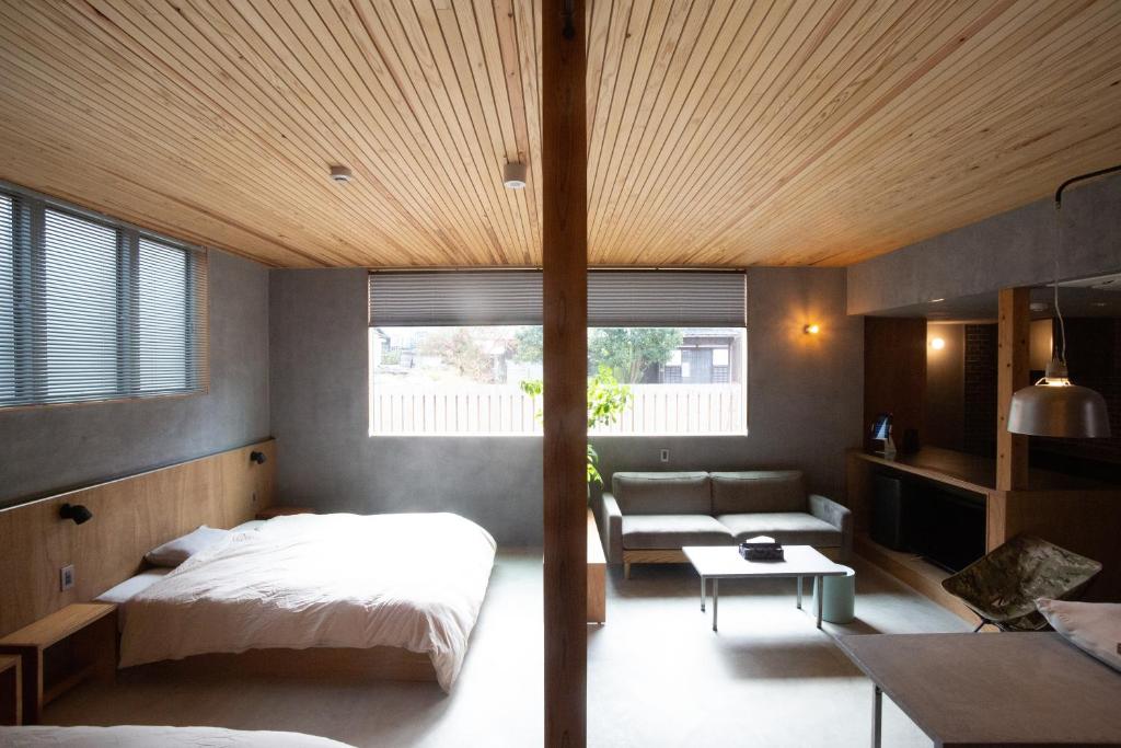 1 dormitorio con 1 cama y 1 sofá en MAGATAMA.INN, en Sumoto