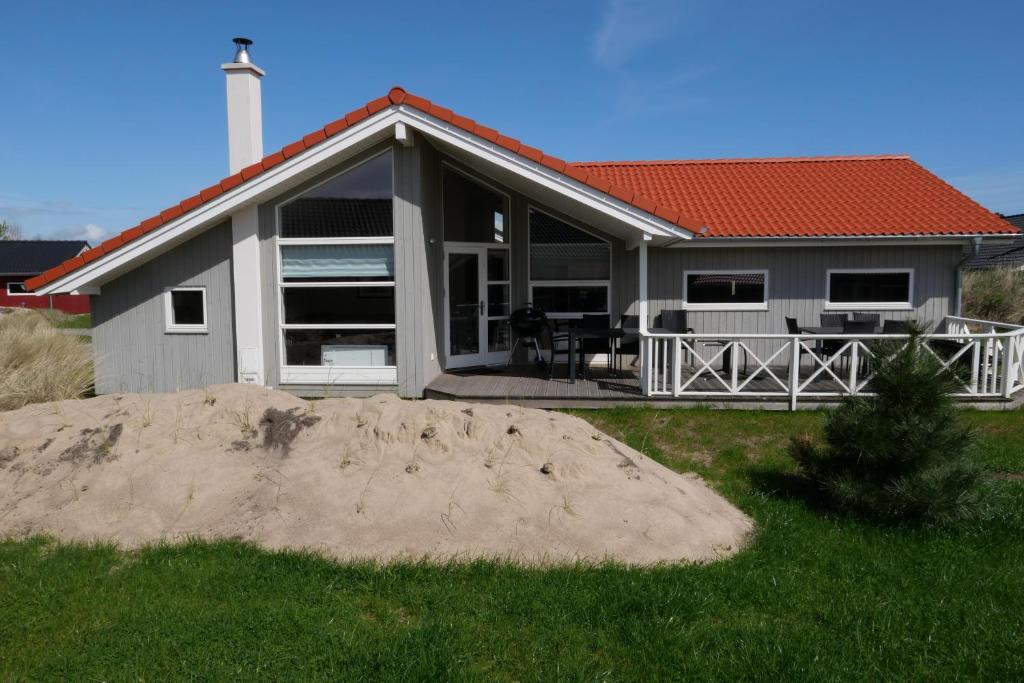 une maison avec un tas de sable devant elle dans l'établissement Resort 2 Ferienhaus Typ D 104, à Großenbrode
