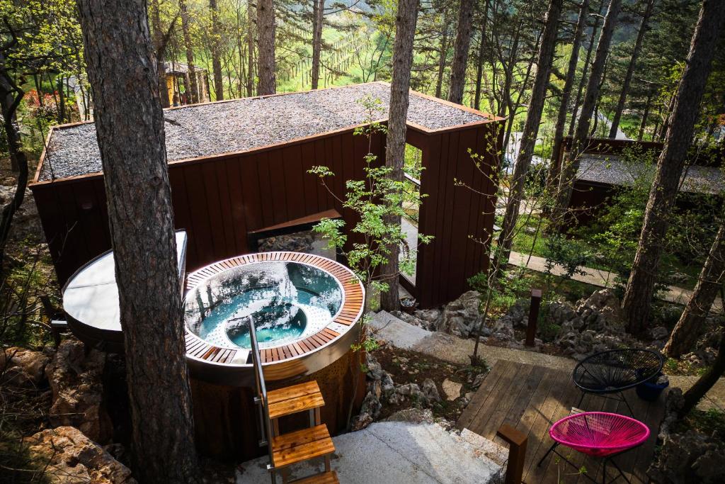 a hot tub in a tree house in the woods at Theodosius Forest Village - Glamping in Vipava valley in Vipava