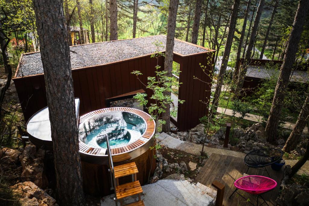 una bañera de hidromasaje en una casa del árbol en el bosque en Theodosius Forest Village - Glamping in Vipava valley, en Vipava