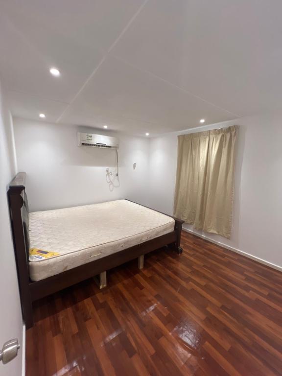Cama en habitación con suelo de madera en Two rooms and one living room in Delma island, en Da‘sah