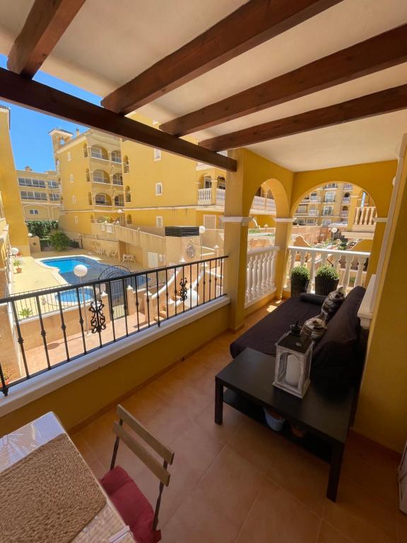 uma varanda com uma cama e vista para uma piscina em Casa Amarela Guesthouse, Algorfa em Algorfa