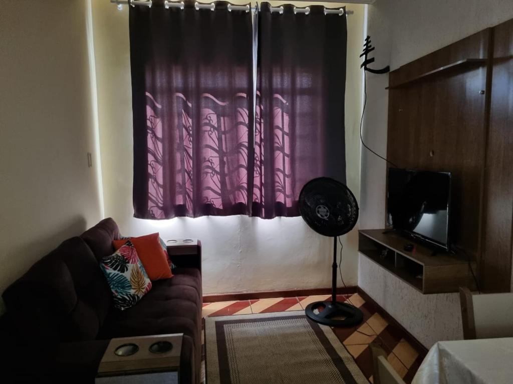 a living room with a couch and a window at Seu Cantin em BH Venda Nova in Belo Horizonte