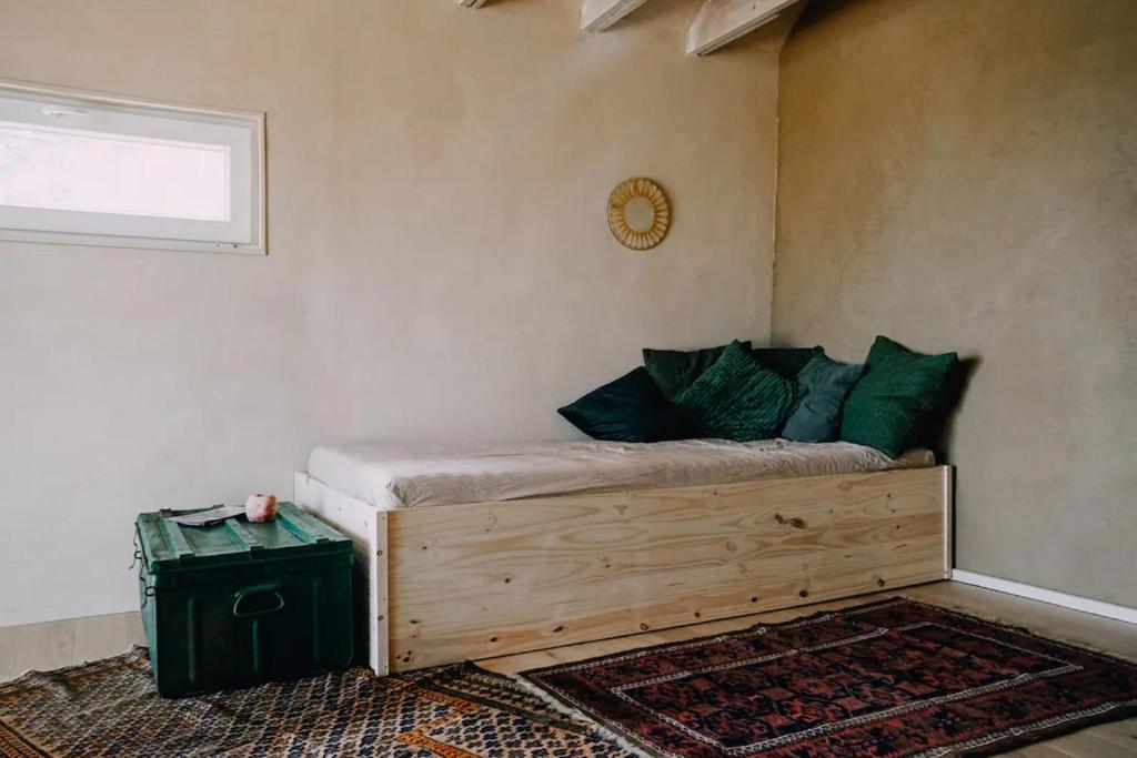 1 dormitorio con cama de madera y almohadas verdes en Eco-friendly WelnessCabin in Liglet en Liglet