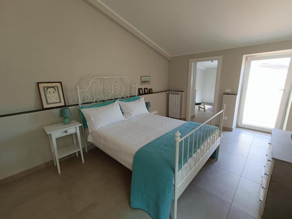ein Schlafzimmer mit einem weißen Bett und einem Fenster in der Unterkunft Le Giramondo Appartamento Carolina in Caserta