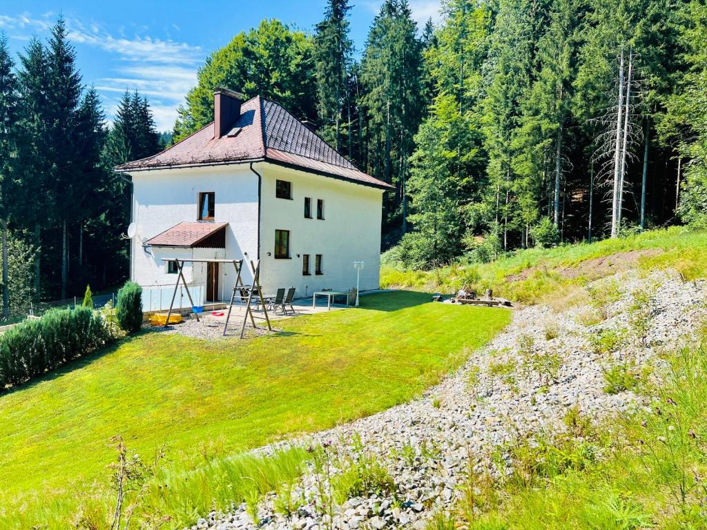 a small white house in the middle of a field at Ferienhaus Lebenskraft in Pfaffetschlag