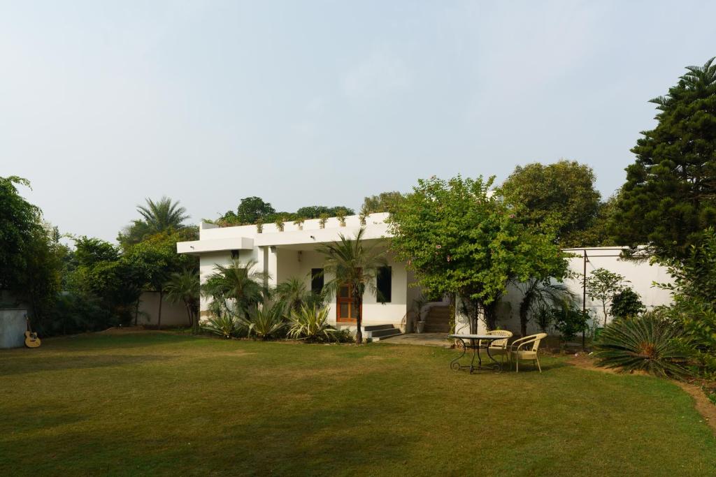 a white house with a yard and a table at Luxury Villa with Swimming Pool in Jaipur