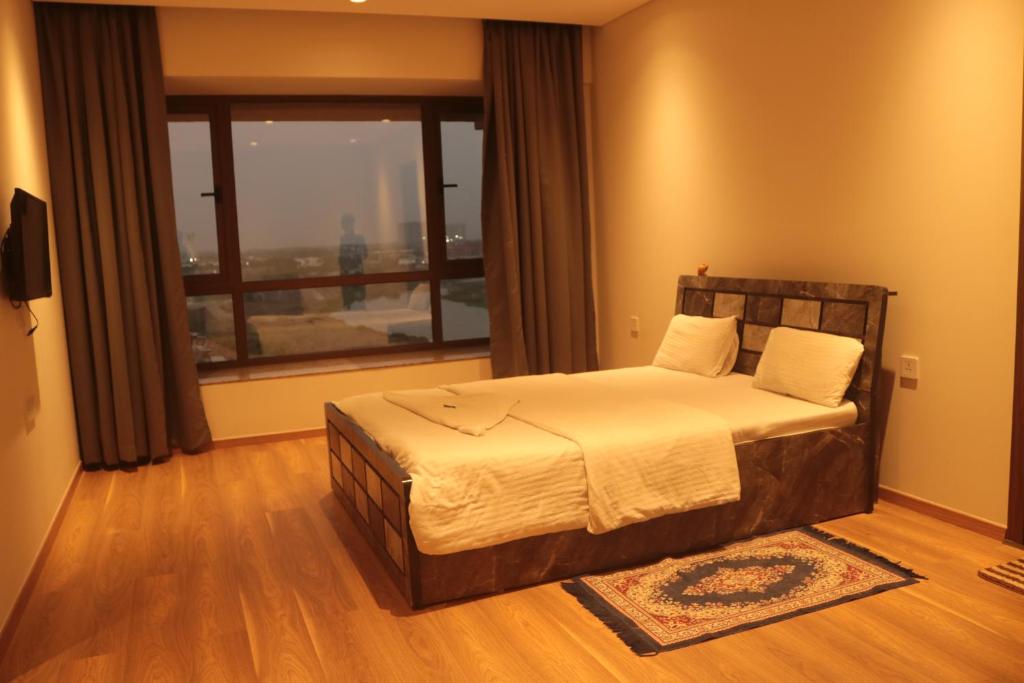 a bedroom with a bed and a large window at Niva Stays Riverside 1 in Kharadi