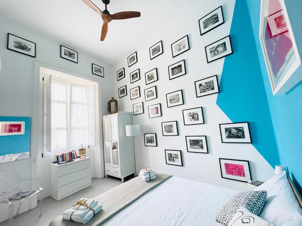 - une chambre avec un mur bleu et blanc avec des photos dans l'établissement 1881 Artistic Royal House, à Caserte