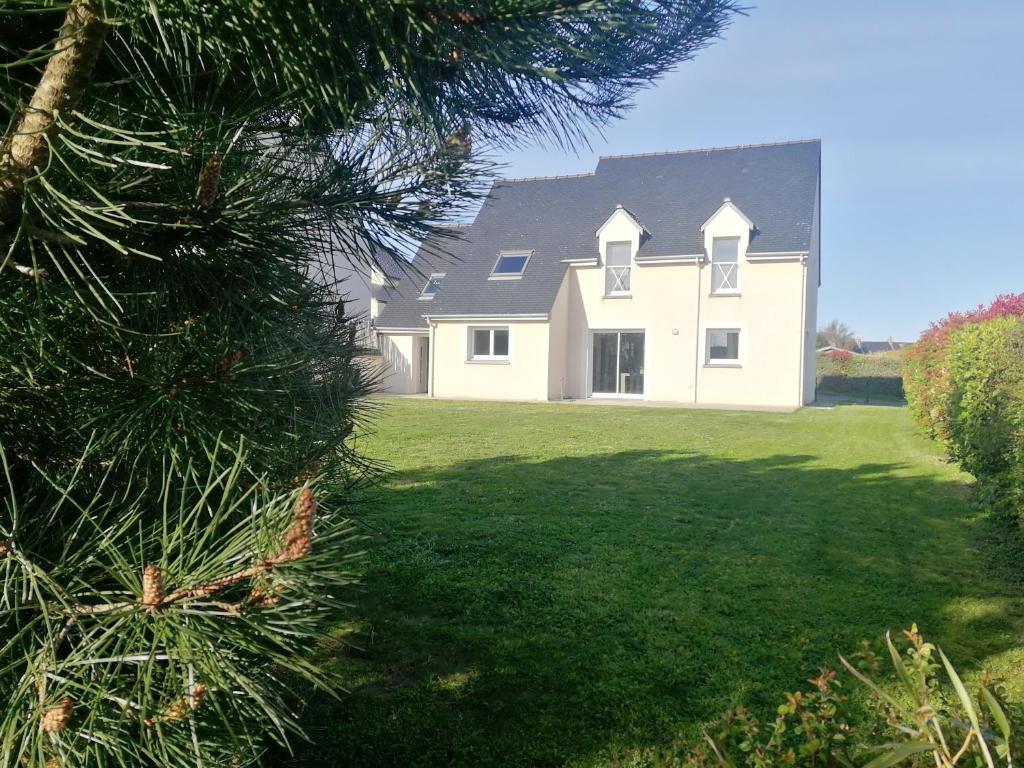 une grande maison blanche avec une grande cour dans l'établissement PLAGES A PIED, à Saint-Coulomb