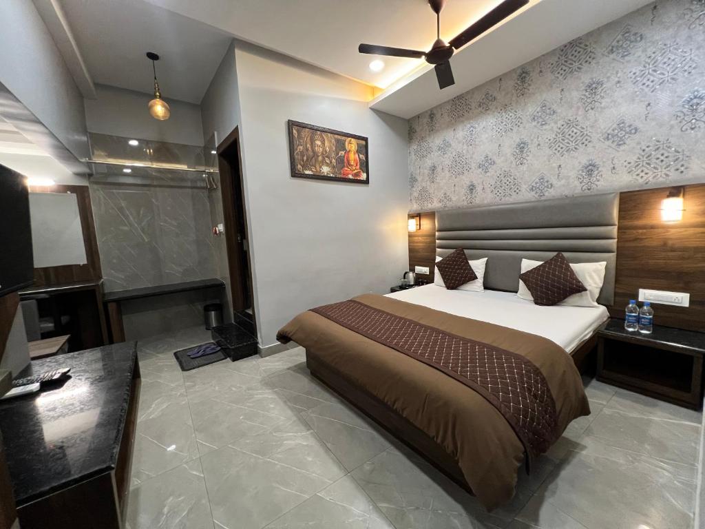 1 dormitorio con 1 cama y TV en Hotel Sabera, en Siliguri