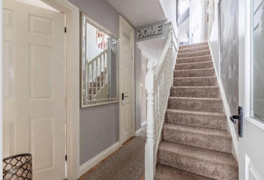 a hallway with a staircase with a white door at Large Bungalow to sleep up to 8 in Slough