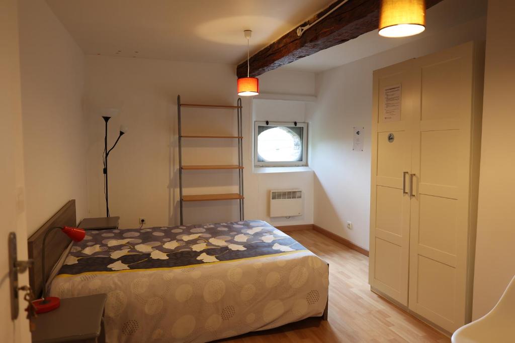 a bedroom with a bed and a ladder and a window at Chambres de la ferme du Brocey in Crolles