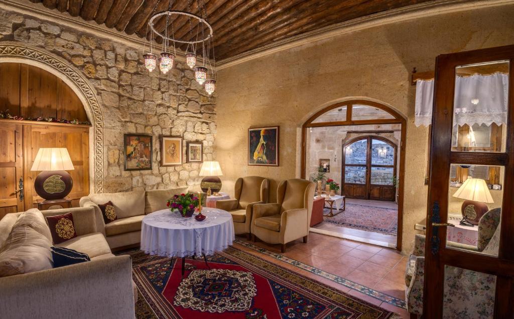 sala de estar con muebles y pared de piedra. en Hotel Temenni Evi, en Ürgüp