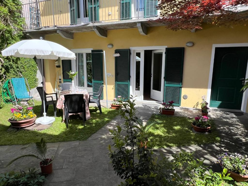patio con tavolo e ombrellone di fronte a casa di Arancio a Verbania
