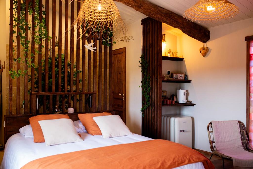 a bedroom with a bed and a chandelier at Mas de l'Amme in Valréas