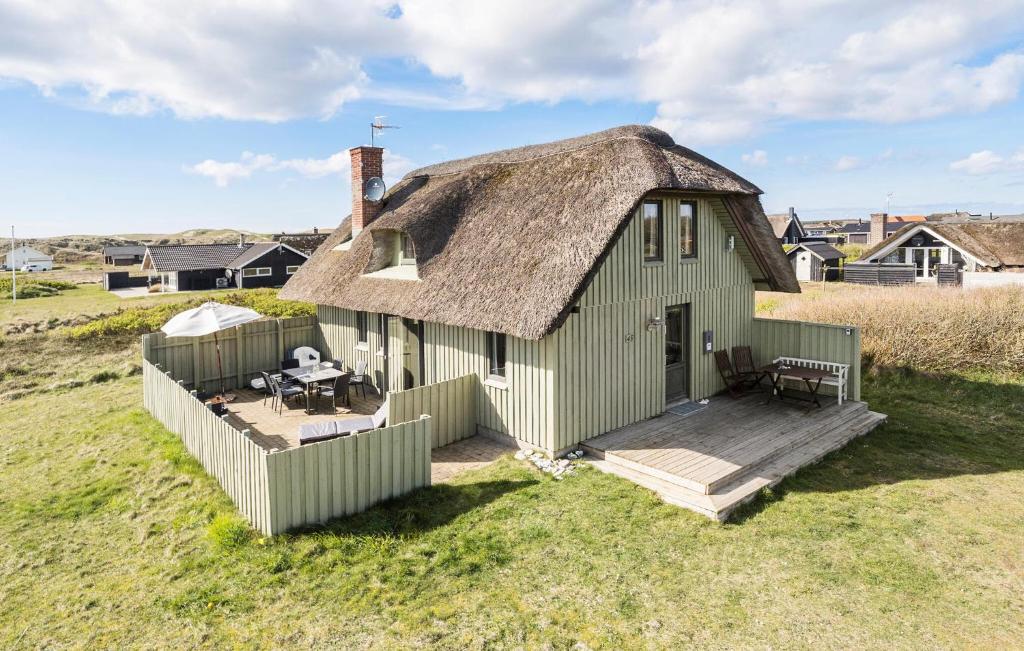uma casa antiga com um telhado de palha e um deque em Awesome Home In Harbore With Wifi em Harboør