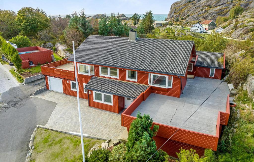 Beautiful Apartment In Hellvik With House Sea View في Hellvik: إطلالة علوية على منزل احمر بسقف