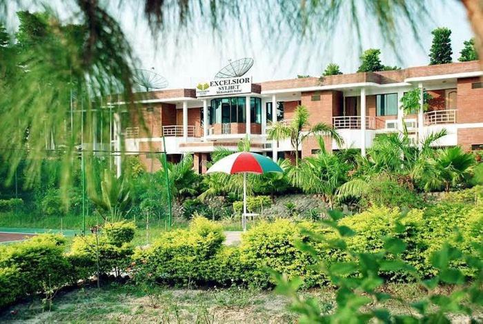 a building with an umbrella in front of it at Excelsior Sylhet Hotel & Resort in Sylhet