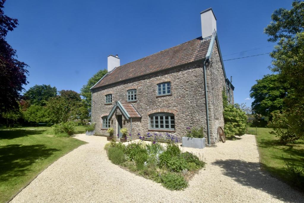 an old stone house with a gravel driveway at Manor Farm House in Bristol