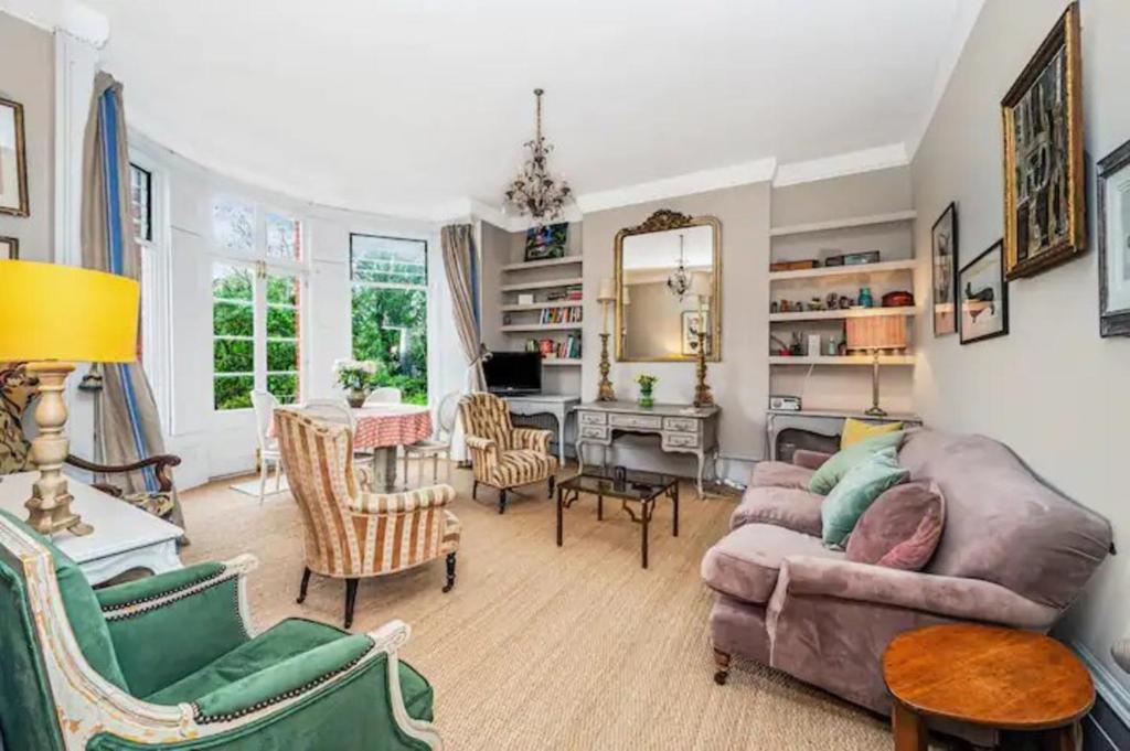 ein Wohnzimmer mit einem Sofa und Stühlen in der Unterkunft Pass the Keys Exquisite Flat - Ten minutes to Central London in London