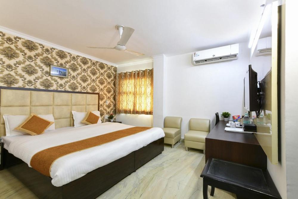 a hotel room with a bed and a television at Hotel First by Goyal Hoteliers in Agra