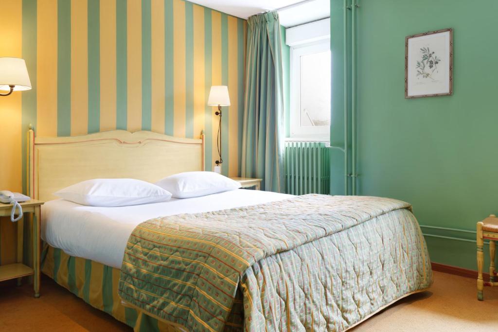 Postel nebo postele na pokoji v ubytování Logis Hôtel Beauséjour Colmar