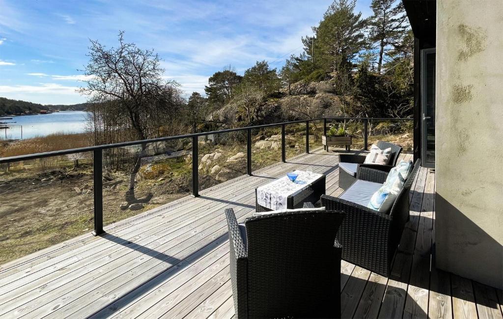 a wooden deck with chairs and a table on a balcony at Cozy Home In Skjrhalden With House A Panoramic View in Skjærhollen