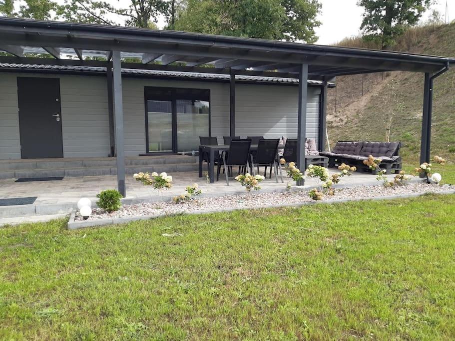 a house with a patio with a table and chairs at Letnisko Skarpa in Giżycko