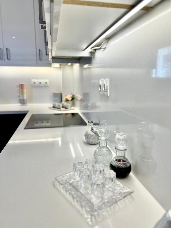 a white kitchen with glass bottles on a counter at Marble luxury villa in Neápolis