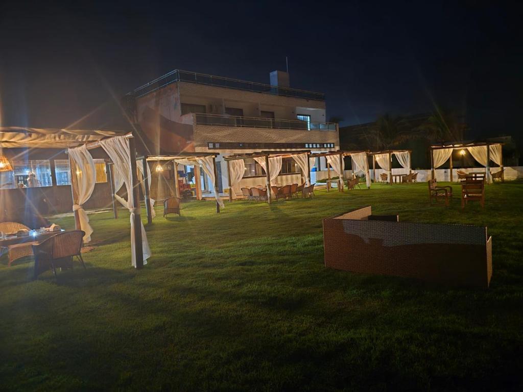 un groupe de tentes dans un champ la nuit dans l'établissement Praia das Tartarugas, à Barra de Tabatinga