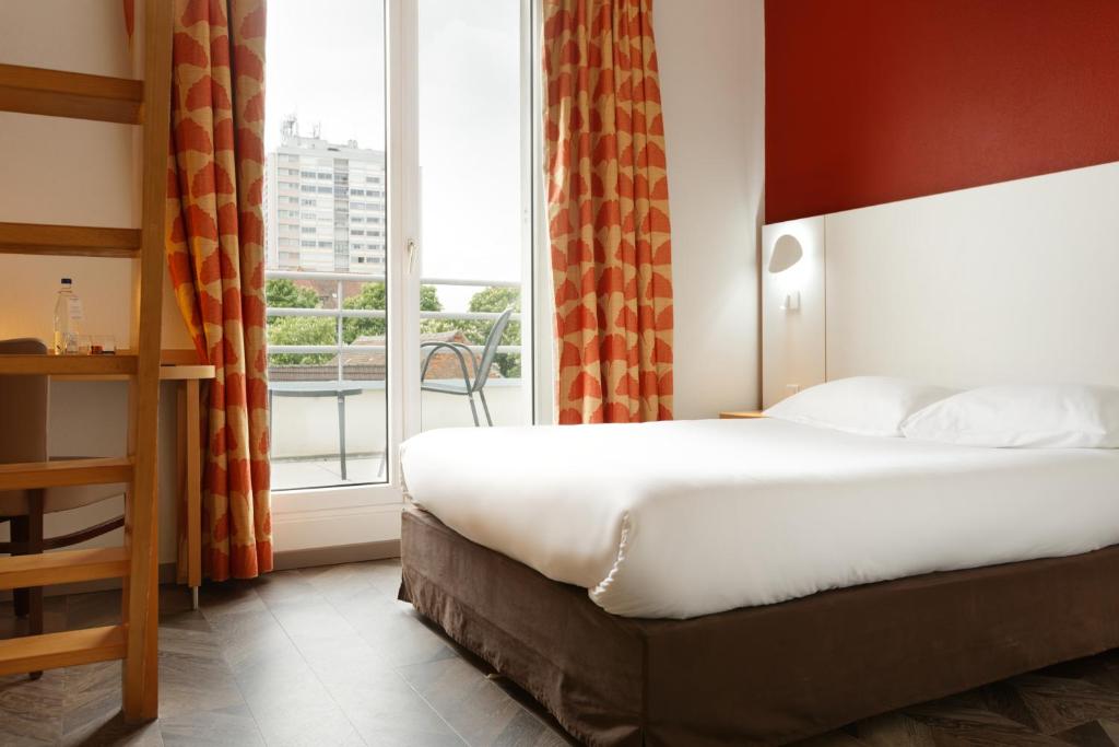 Postel nebo postele na pokoji v ubytování Logis Hôtel Beauséjour Colmar