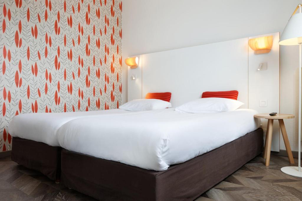 Postel nebo postele na pokoji v ubytování Logis Hôtel Beauséjour Colmar