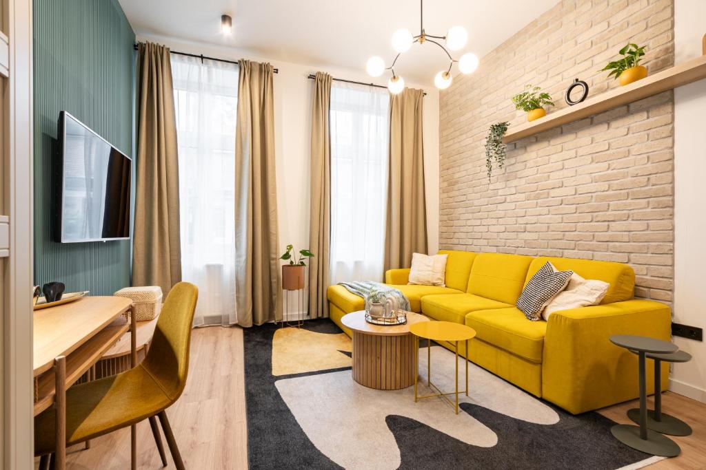 uma sala de estar com um sofá amarelo e uma mesa em Downtown Delight: An Artsy and Homelike Haven em Budapeste