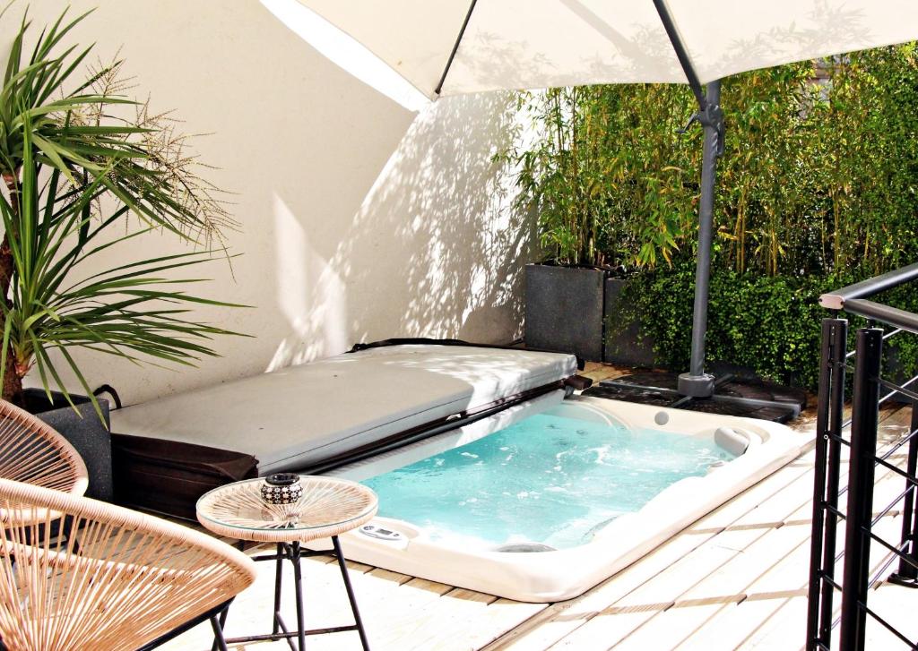- un bain à remous sur une terrasse avec un parasol dans l'établissement Super Central, Spacious, Sunny Large Deck & SPA, à Cannes