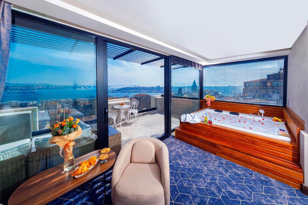 a bedroom with a tub and large windows at Ring Stone Hotels Bosphorus - Special Class in Istanbul