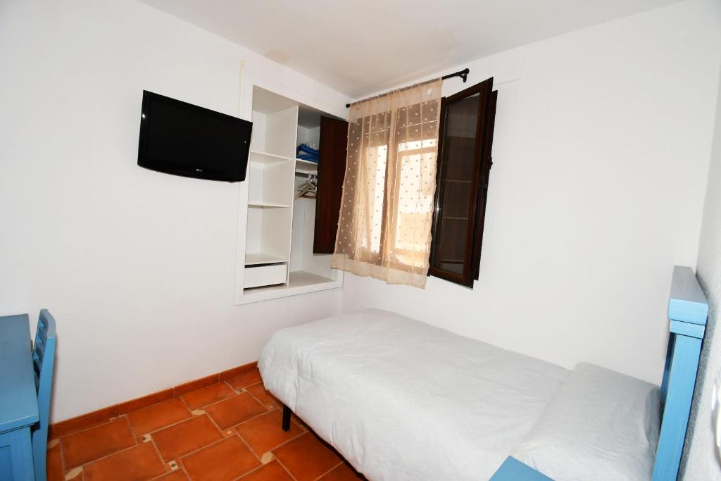1 dormitorio pequeño con 1 cama y TV en La Fragua de la Villa, 
