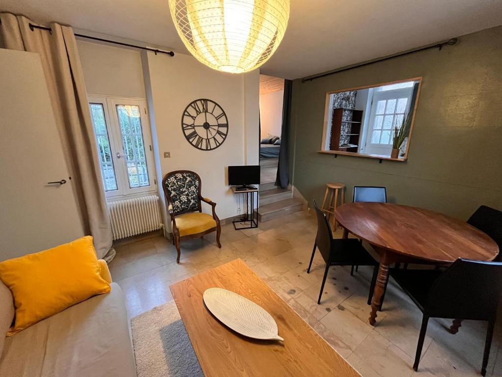 un salon avec une table et des chaises en bois dans l'établissement Charmante maison, à Auxerre