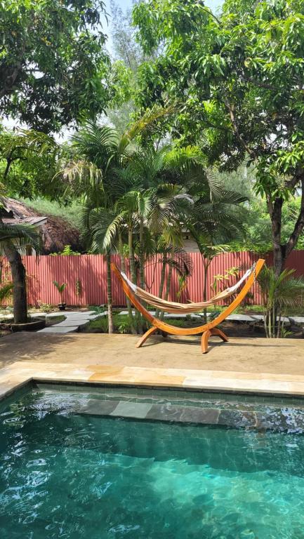 - un hamac installé sur une terrasse à côté de la piscine dans l'établissement The Barefoot Blondie Village, à Gili Air