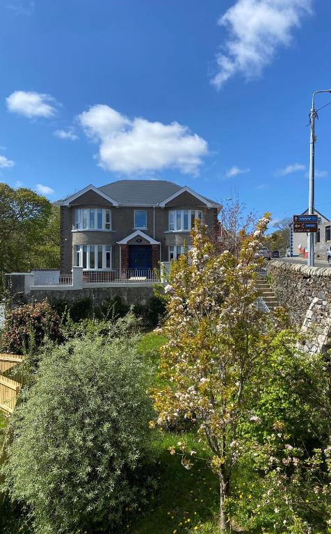 a large house on top of a hill with trees at Carrick Gate in Carrick