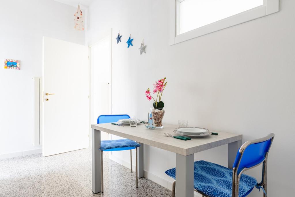 une salle à manger avec une table et des chaises bleues dans l'établissement La conchiglia dei sogni - YourPlace Abruzzo, à Rocca San Giovanni