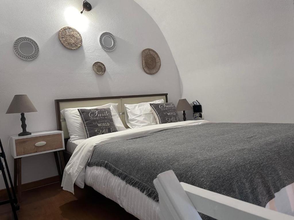 una camera con un grande letto e una parete bianca di Mare Nostrum Santo a Oia