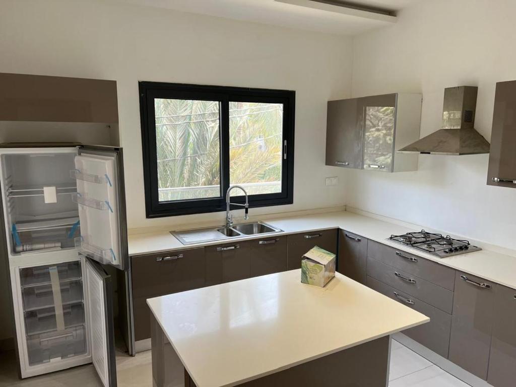 an empty kitchen with a sink and a window at Appartement F4 in Dakar