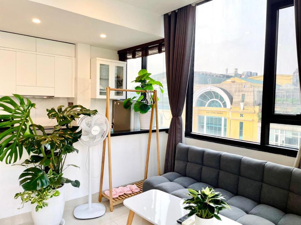 uma sala de estar com um sofá e algumas plantas em Kem Apartment 18 Ngô Quyền em Hanói