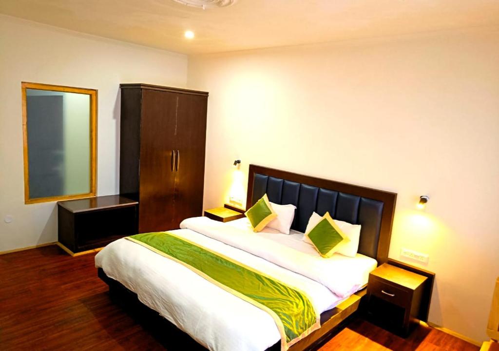 a bedroom with a large bed with green pillows at Apricuss hotel in Leh