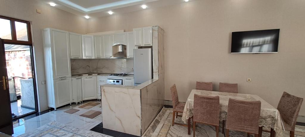 a kitchen with a table with chairs and a refrigerator at Göygöl Aşıqlı in Aşıqlı