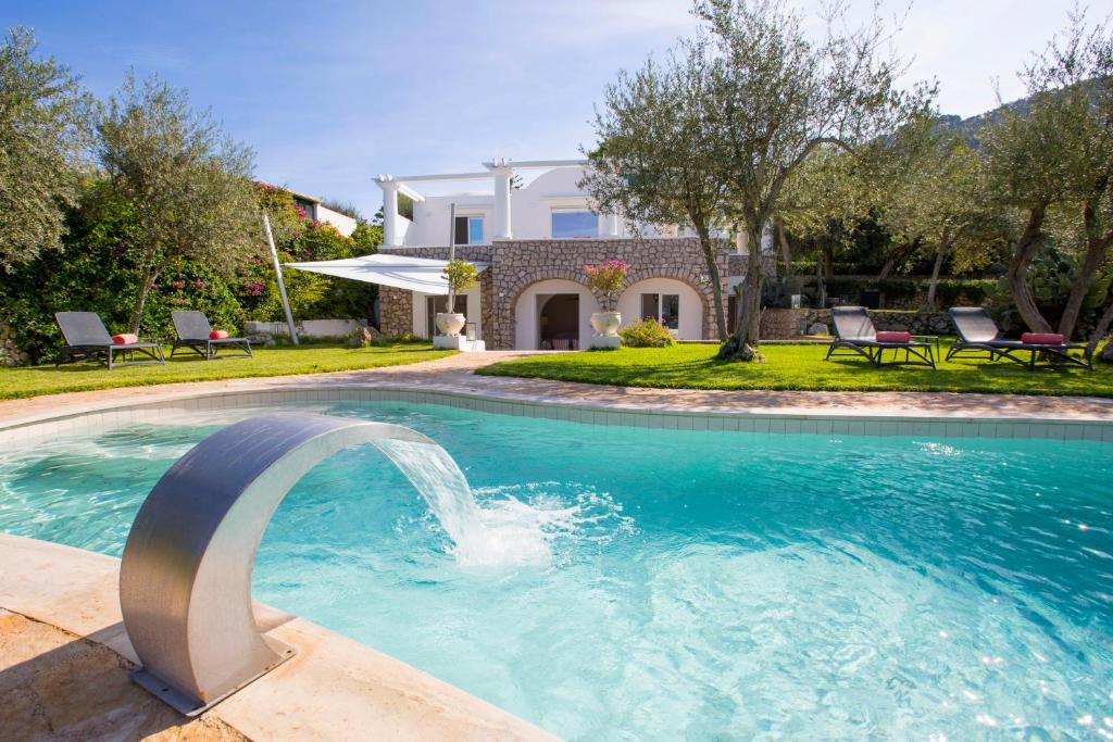 a pool with a fountain in front of a house at Villa Serenity garden & pool in Anacapri